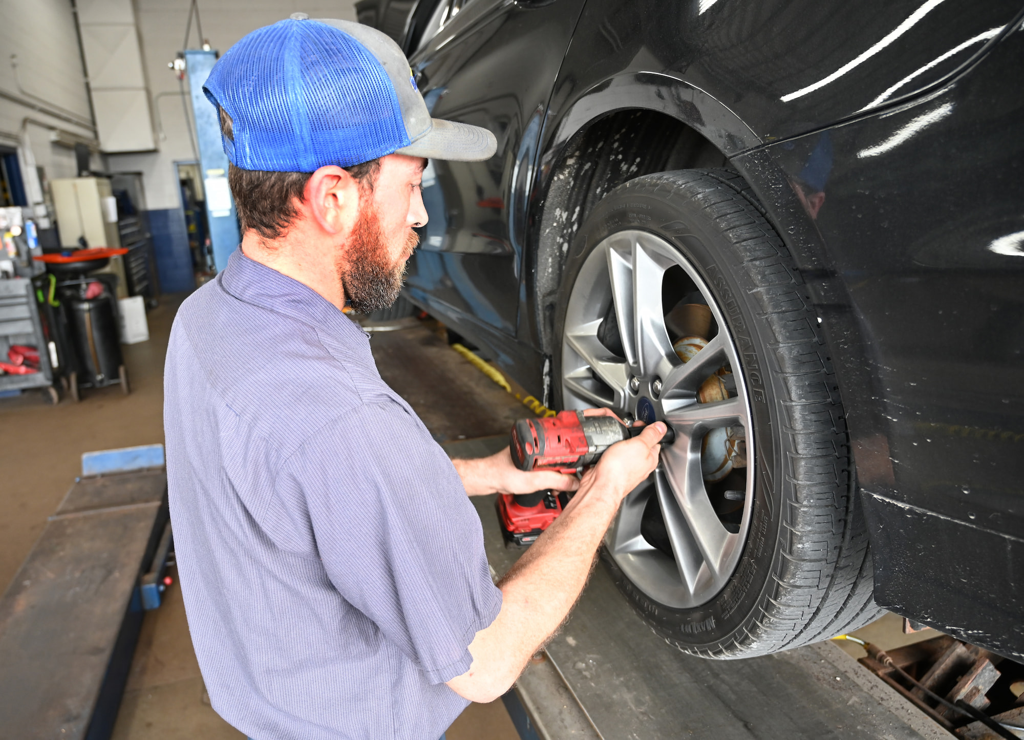Auto technician torquing lug nuts during a tire installation
