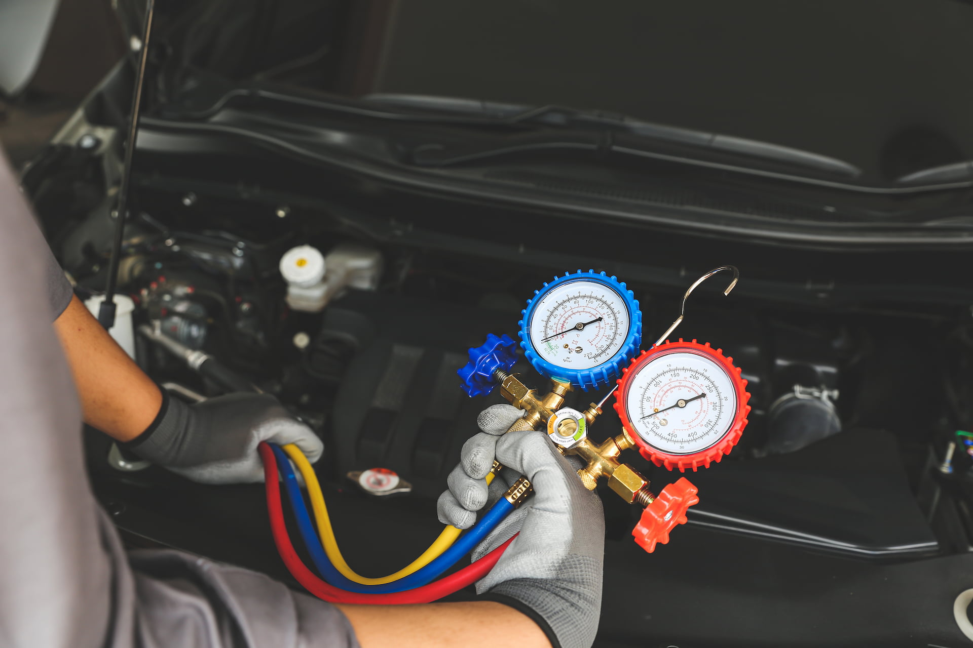 AC refrigerant gauge check during car AC repair in Green Bay Wi