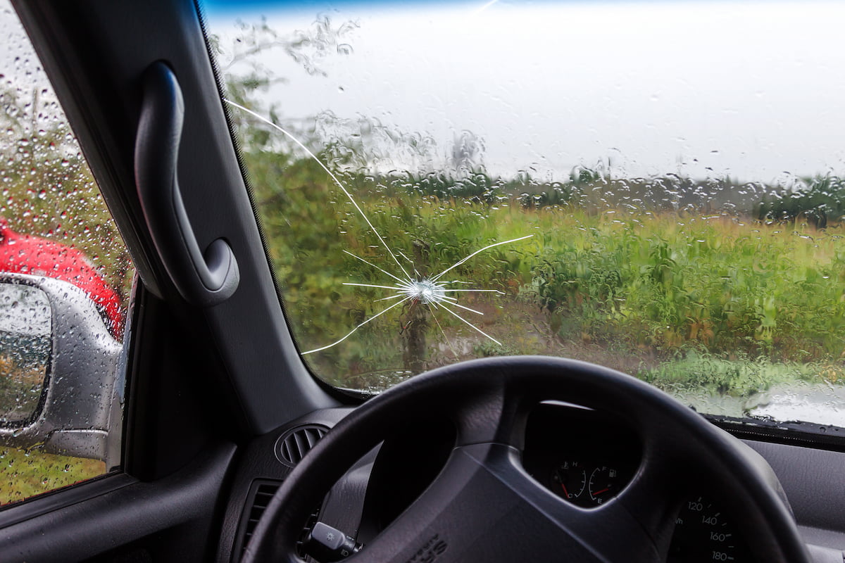 A cracked windshield in rainy weather